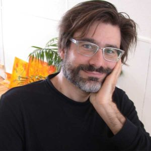 Smiling man with beard, wearing glasses.