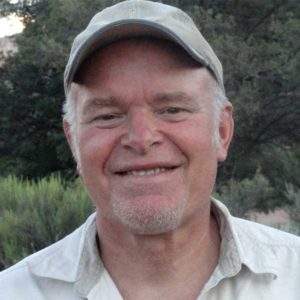 Man wearing baseball hat, smiling into the camera.