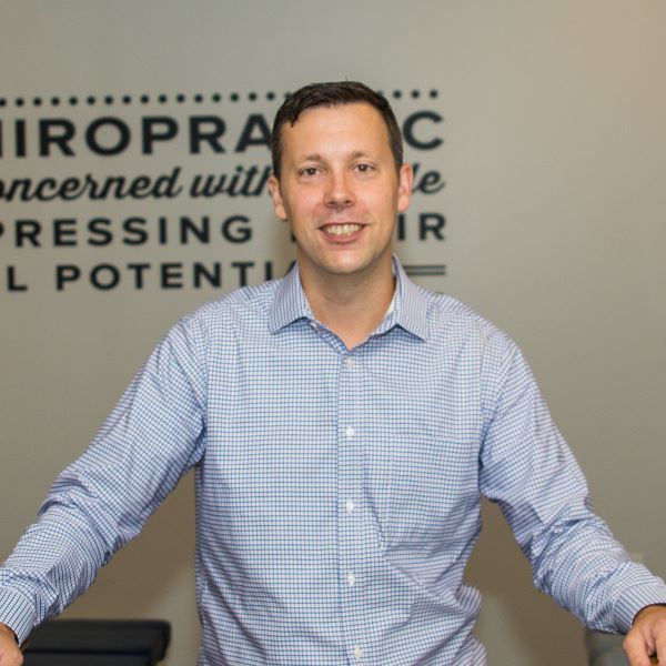 Young man with short hair, smiling onto the camera.